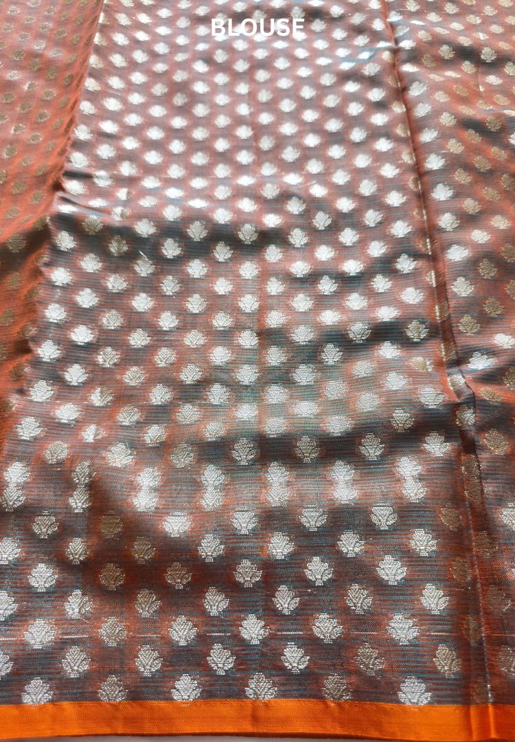 Dark fabric with woven zari butis and orange edge, detail of the Teal Blue Pichwai Kota silk saree