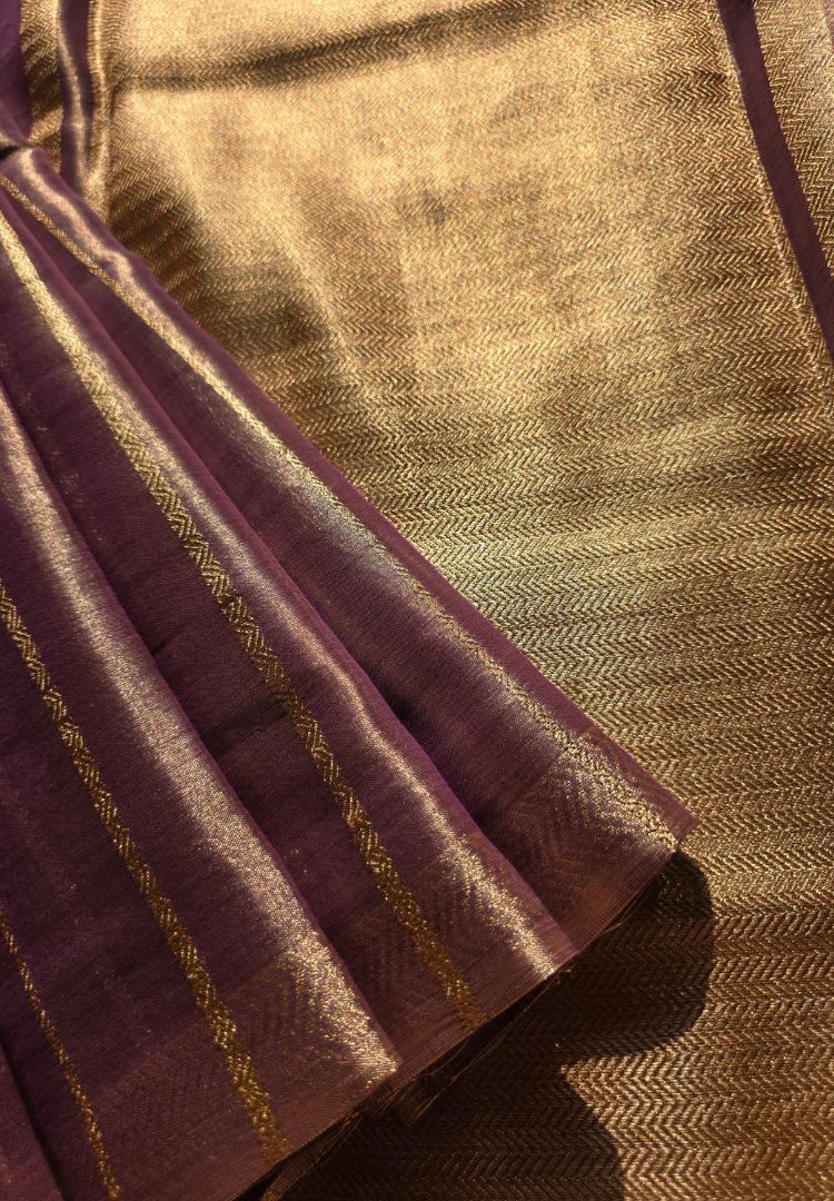 Gold zari bands on the pallu of a lavender katan tissue saree