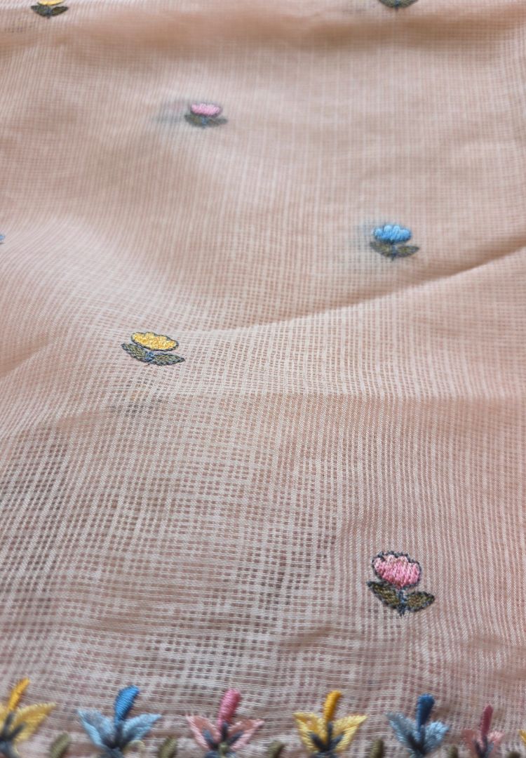 Small hand embroidered motifs scattered on the pastel peach Kota saree body