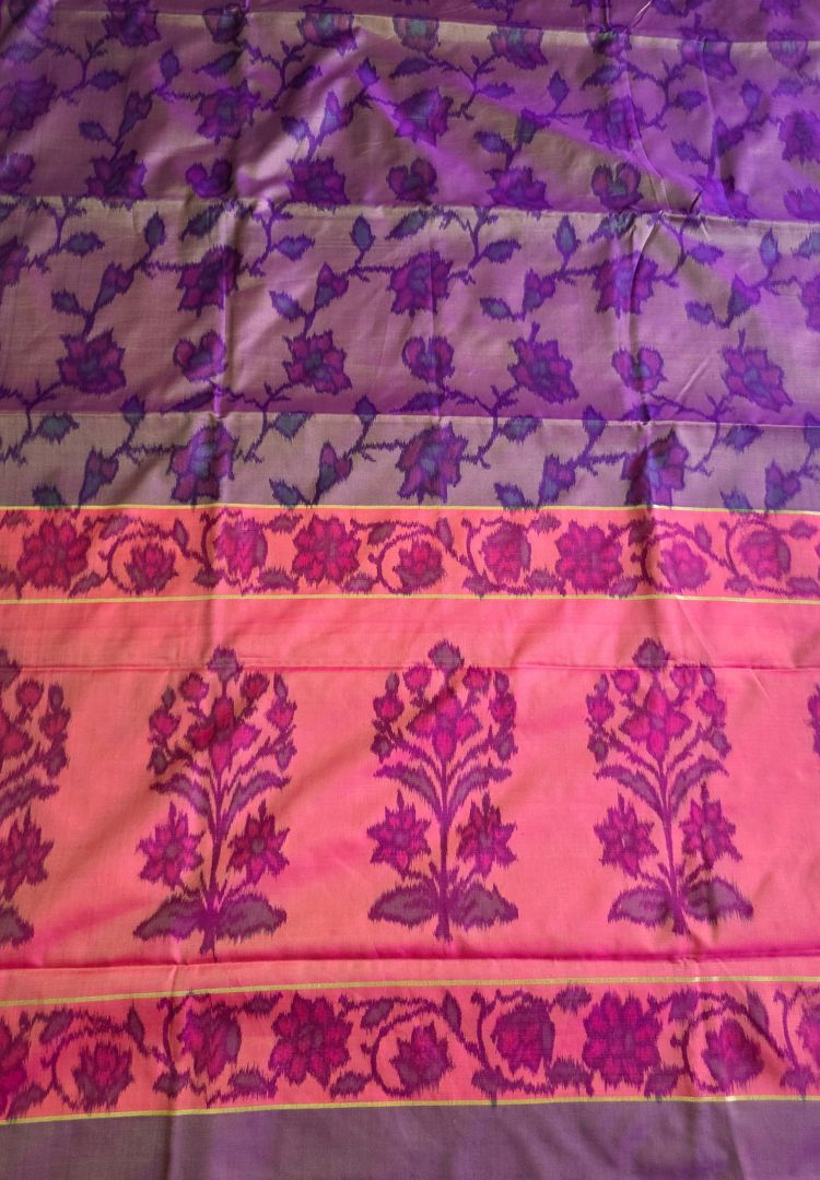 Close-up of Ikkat motifs on the pink pallu of a magenta and gold silk saree
